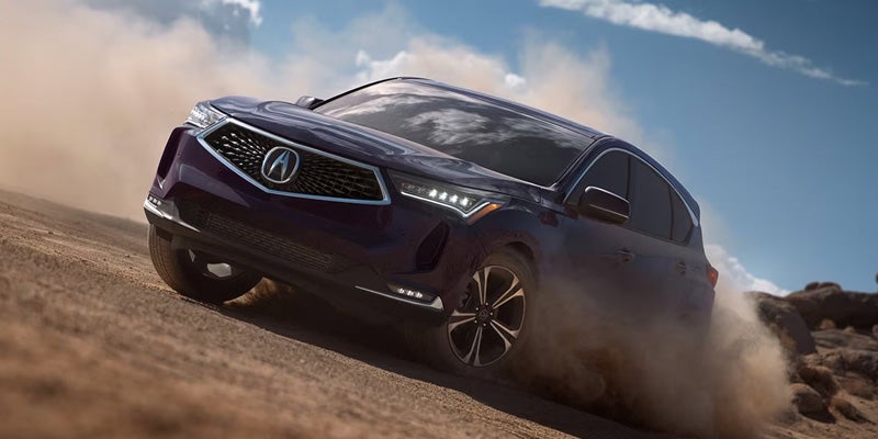 Acura SUV driving off-road through a dusty landscape