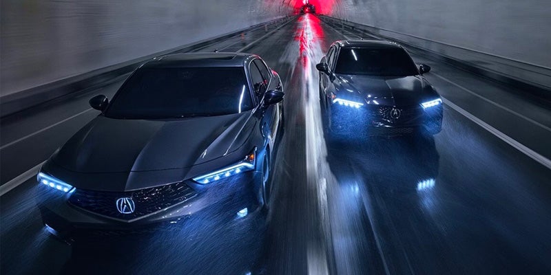 Two Acura vehicles driving side by side through a tunnel, featuring bright LED headlights