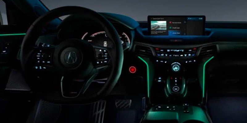Acura sedan driver cockpit showing the steering wheel, digital instrument cluster, center display