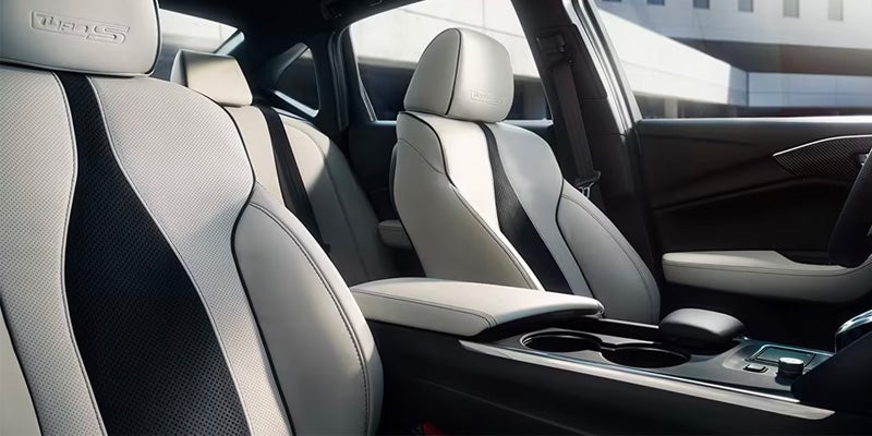 Acura sedan interior featuring light-colored sport seats, center console, and premium cabin materials