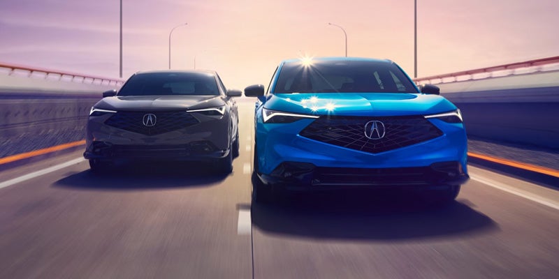 Two Acura SUVs driving side by side on a highway