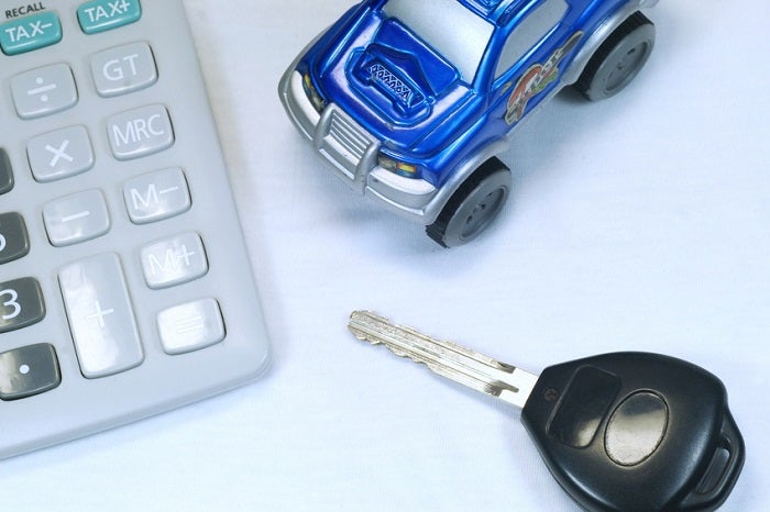 Calculator, keys, and toy car representing Acura interest rates
